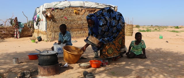 Amina, 37, prepares food with two of her five children in a displacement camp, after fleeing her village of Tchoma Bangou as a result of an attack in which more than 100 people were killed and granaries were burned, Tillabéri region, Niger, 1 August 2021. “In my family, they killed 12 people,” she told Amnesty International. “We miss our village so much, our presence here [in the camp] is just to save our lives.”