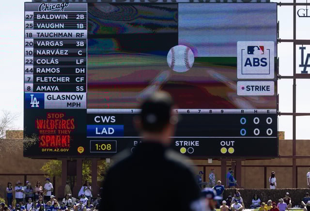 Mar 2, 2025; Phoenix, Arizona, USA; An umpire looks at the Jumbotron during an automated ball-strike challenge aka ABS in the Los Angeles Dodgers game against the Chicago White Sox during spring training at Camelback Ranch-Glendale. Mandatory Credit: Mark J. Rebilas-Imagn Images