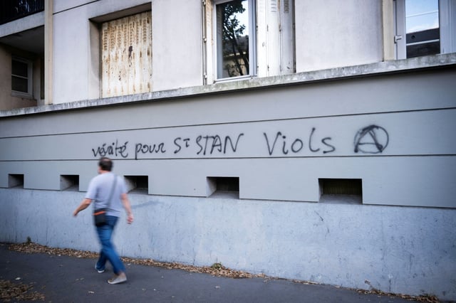 Un homme passe devant un graffiti dans une rue proche de l'entrée du lycée privé catholique et du Collège Saint-Stanislas à Nantes, le 29 août 2025
