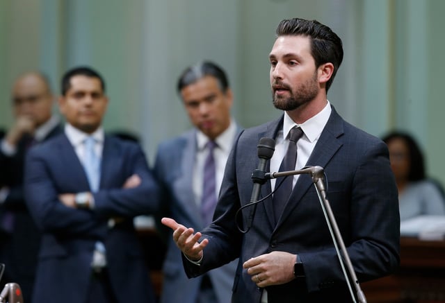 FILE - Assemblyman Ian Calderon, D-Whittier, urges lawmakers to approve a measure to give new wage and benefit protections at the so-called gig economy companies like Uber and Lyft, during the Assembly session in Sacramento, Calif., Sept. 11, 2019. (AP Photo/Rich Pedroncelli, File)
