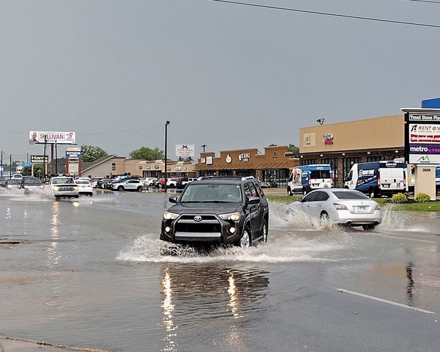 Cars make their way through the flooded street on Wednesday, May 22, 2024, along Nettleton Avenue in Jonesboro, Ark. Between the high winds and sudden downpour, the storm caused several issues across town included power outages, flying debris, signal light outages and downed trees and limbs. (Gretchen Hunt/The Jonesboro Sun via AP)