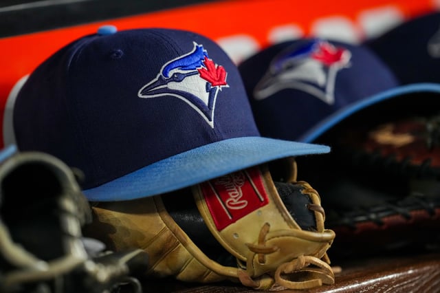 MIAMI, FLORIDA - AUGUST 23: Toronto Blue Jays hats and gloves sit in the dugout during the sixth inning of their game against the Miami Marlins at loanDepot park on August 23, 2025 in Miami, Florida. (Photo by Jared Lennon/Getty Images)