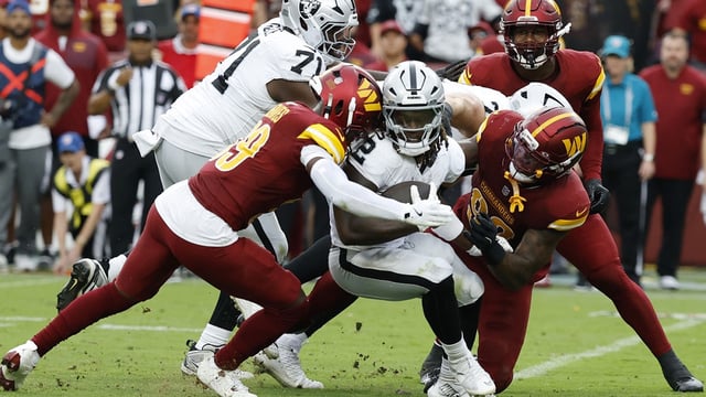 Sep 21, 2025; Landover, Maryland, USA; Las Vegas Raiders running back Ashton Jeanty (2) is tackled by Washington Commanders safety Jeremy Reaves (39) and Commanders defensive end Dorance Armstrong (92) during the third quarter at Northwest Stadium. Mandatory Credit: Geoff Burke-Imagn Images