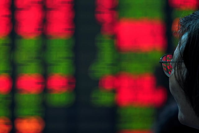 An investor looks at an electronic board showing stock information at a brokerage house in Shanghai, China July 6, 2018. REUTERS/Aly Song/File Photo