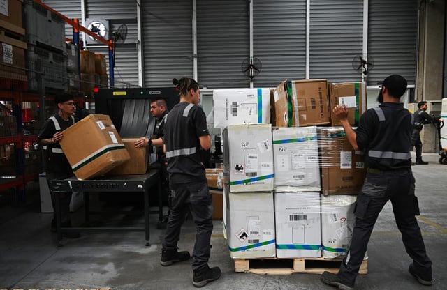 Des employés trient des colis à l’aéroport international de Santiago, le 12 novembre 2024.
