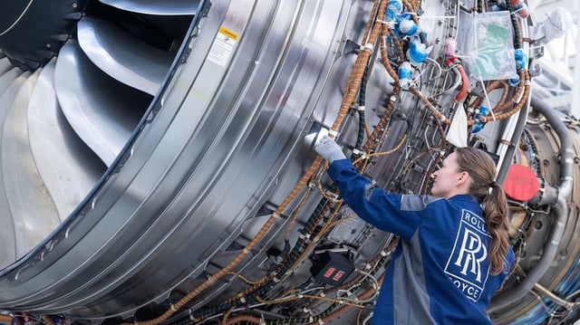 Eine Mitarbeiterin inspiziert im Rolls-Royce Werk Dahlewitz ein Triebwerk.