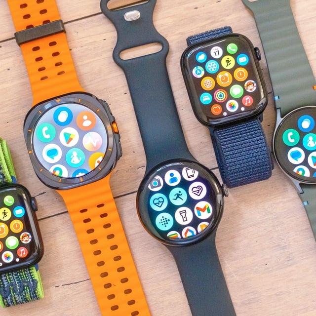 A close-up of five smartwatch on a wooded surface including the Apple Watch SE, Samsung Galaxy Watch Ultra, Google Pixel Watch 3 XL, Apple Watch 10 and Samsung Galaxy Watch 7
