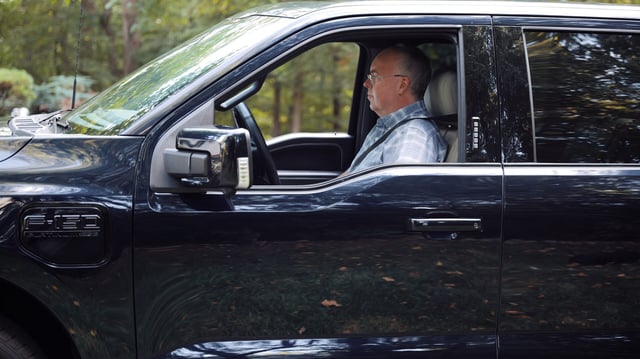 A man sits in a Ford F-150 Lightning