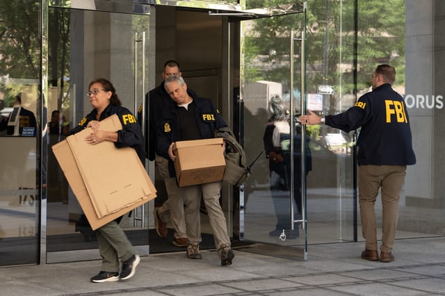 FBI agents leave the office of John Bolton, former national security adviser to President Trump, with several boxes and other materials on August 22, 2025 in Washington, DC.