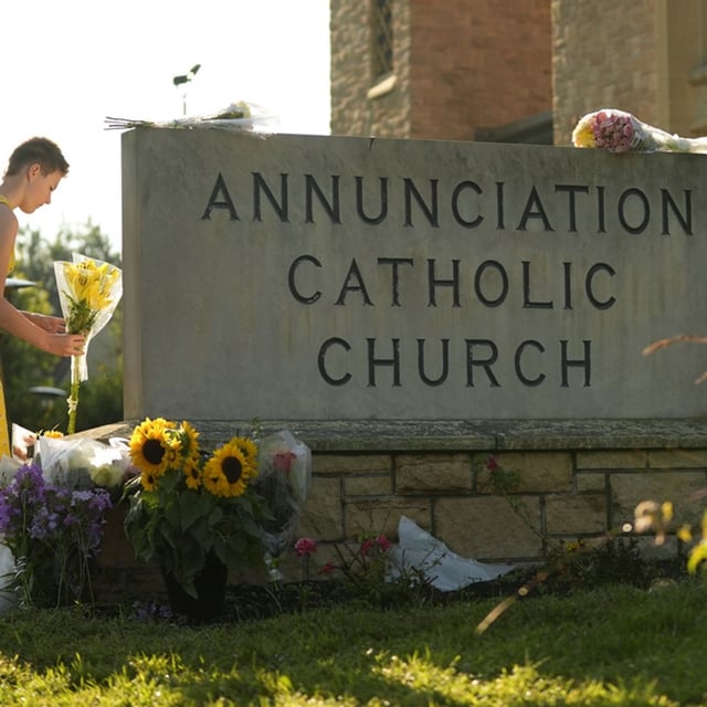 Ruth, right, and Sage place flowers at a memorial at Annunciation Catholic Church after Wednesday's school shooting, Thursday, Aug. 28, 2025, in Minneapolis. (AP Photo/Abbie Parr)