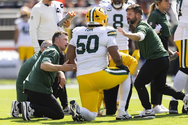 Sep 21, 2025; Cleveland, Ohio, USA; Green Bay Packers offensive tackle Zach Tom (50) is attended to by medical personnel for an on field injury during the first quarter against the Cleveland Browns at Huntington Bank Field. Mandatory Credit: Scott Galvin-Imagn Images