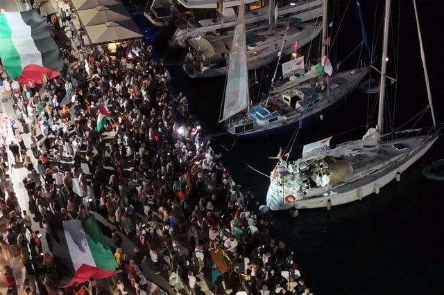 A screenshot from a drone video shows people gathering at the port of Ermoupolis during the departure of two sailing boats, Electra and Oxygen, part of the Global Sumud Flotilla aiming to reach Gaza and break Israel's naval blockade, on Syros island, Greece, September 14, 2025. REUTERS/Giorgos Solaris