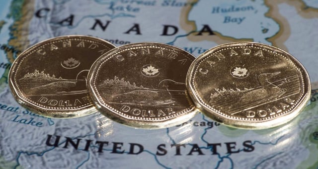 The weak Canadian dollar and the trade war with the United States is expected to boost Quebec's tourism economy this year. Canadian dollar coins are displayed on a map along the border of Canada and the United States of America, in a Jan. 9, 2014 file photo. THE CANADIAN PRESS/Paul Chiasson