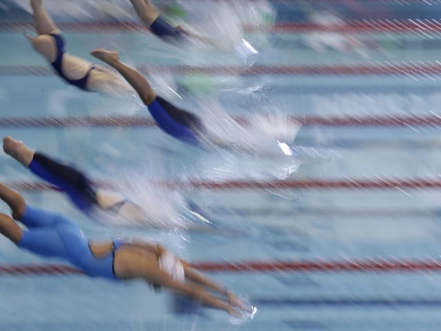 Competitors dive from the starting blocks in the women's 100-meter freestyle S8 final at the World Para Swimming Championships in Mexico City, Sunday, Dec. 3, 2017. The World Para Swimming and Para Powerlifting championships are taking place in Mexico's capital through Dec. 8.