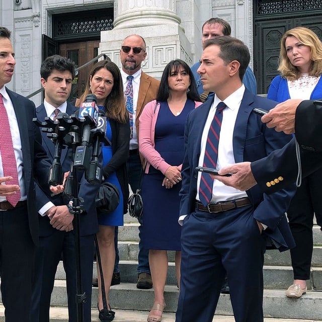 FILE - Attorneys Joshua Koskoff, left, and Christopher Mattei, right, representing parents, rear, of children killed in the 2012 Sandy Hook Elementary School shooting, speak outside the Connecticut Supreme Court, Sept. 26, 2019, in Hartford, Conn. (AP Photo/Dave Collins, File)