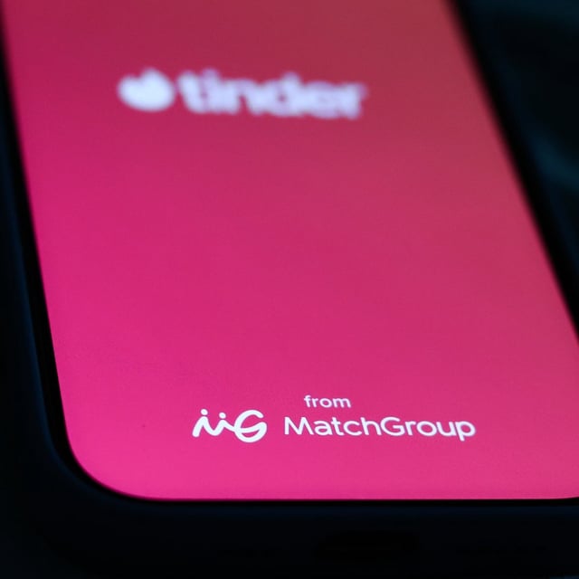 Tinder and Match Group logo displayed on a phone screen