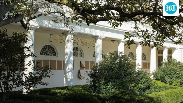 The presidential walk of fame is written on a wall, above pieces of brown paper placed in the colonnade outside the Oval Office