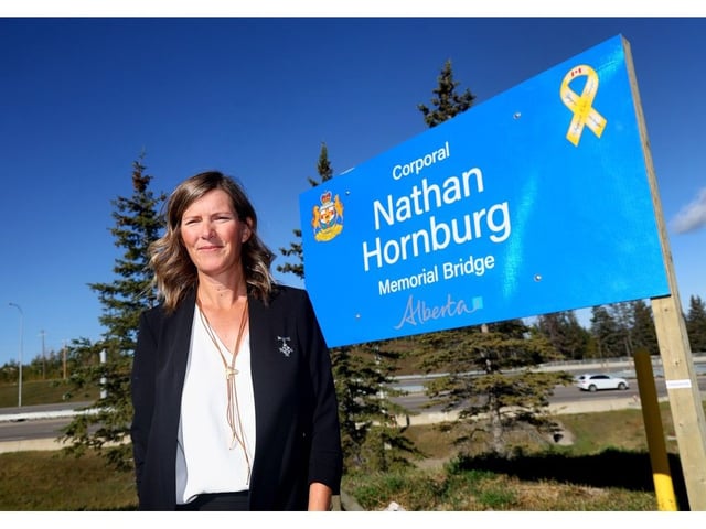  Rachel Herbert, Corporal Nathan Hornburg’s sister at a sign for a bridge on Stoney Trail that has been named in his honour.