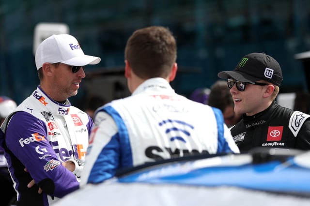 Denny Hamlin, driver of the #11 FedEx Express Toyota, (L) Christopher Bell, driver of the #20 SiriusXM Toyota, and Ty Gibbs, driver of the #54 He Get us Toyota, (R) talk on the grid during practice for the NASCAR Cup Series Pennzoil 400 at Las Vegas Motor Speedway on March 04, 2023 in Las Vegas, Nevada.