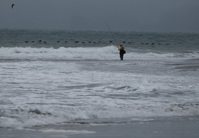 Un pêcheur au bord de l'océan Pacifique, le 30 juillet 2025 à San Francisco (Californie)