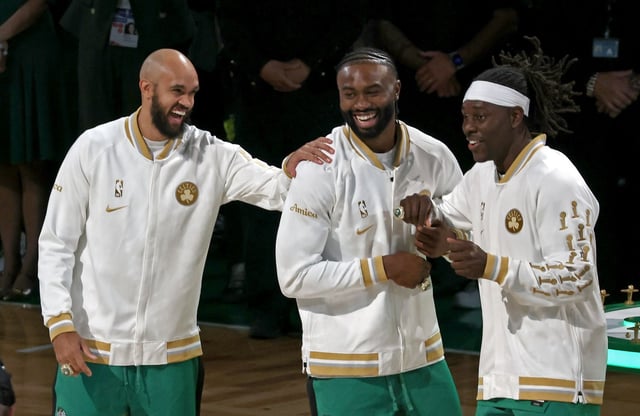 Boston Celtics stars, from left, Derrick White, Jaylen Brown and Jrue Holiday joke before the Celtics raised their latest championship banner to the rafters Tuesday night. (Staff Photo/Stuart Cahill/Boston Herald)