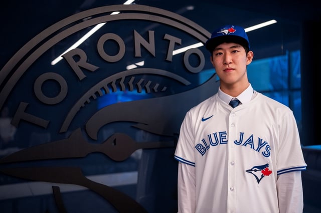 South Korean pitcher Moon Seo-jun poses in his new Toronto Blue Jays uniform following his signing ceremony at Rogers Centre in Toronto on Sept. 24, 2025, in this photo provided by Leeco Sports Agency. (PHOTO NOT FOR SALE) (Yonhap)