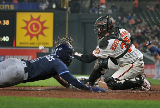 Orioles catcher Adley Rutschman, right, awaits the ball as Rays’ Chandler Simpson, left, dives for home plate in the seventh inning at Oriole Park at Camden Yards. (Kenneth K. Lam/staff)