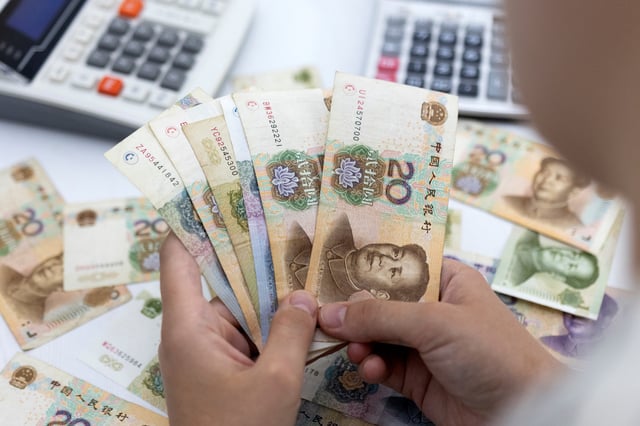 Woman holds Chinese Yuan banknotes in this illustration taken May 30, 2022. REUTERS/Dado Ruvic/Illustration/File Photo