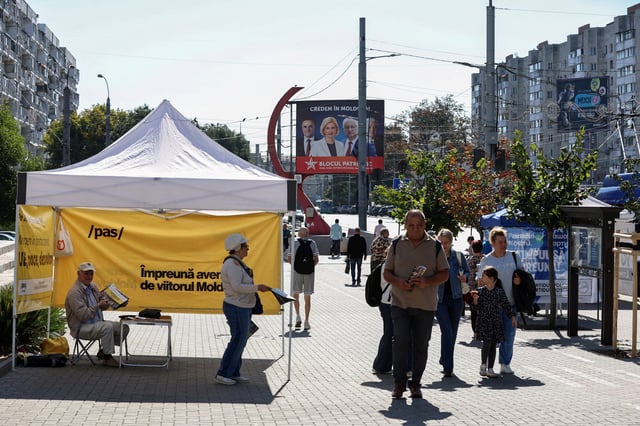 Participants of the Party of Action and Solidarity (PAS) campaign hand out leaflets ahead of Moldova's upcoming parliamentary elections in Chisinau, Moldova, September 21, 2025. REUTERS/Vladislav Culiomza/File Photo