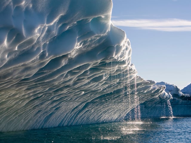 Schmelzwasser fließt aus einem Eisberg, der vom Ilulissat Kangerlua-Gletscher 
