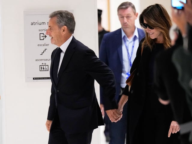 25.09.2025, Frankreich, Paris: Der ehemalige französische Präsident Nicolas Sarkozy und seine Frau Carla Bruni Sarkozy kommen in den Gerichtssaal, um das Urteil über die mutmaßliche illegale Finanzierung seiner Präsidentschaftskampagne 2007 durch die Regierung des damaligen libyschen Führers Moammar Gaddafi entgegenzunehmen.