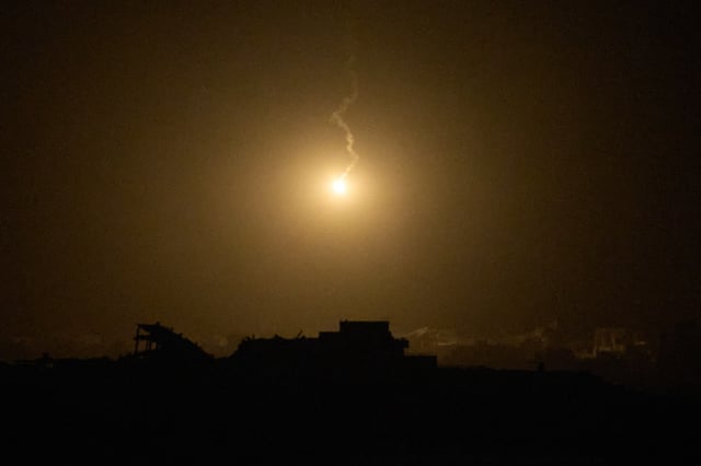 An Israeli army flare drifts over buildings destroyed during Israeli ground and air operations in the northern Gaza Strip, as seen from southern Israel, Thursday, Sept. 25, 2025. (AP Photo/Leo Correa)