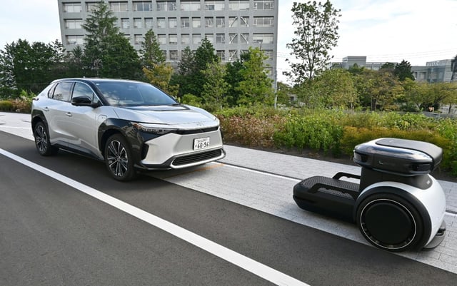 An autonomous robot guides shared cars inside Toyota's new "Woven City", a high-tech village opened to test autonomous driving and other futuristic developments