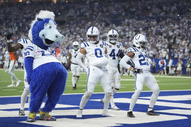 Indianapolis Colts safety Cam Bynum celebrates an interception with the Indianapolis Colts mascot Blue and cornerback Kenny Moore II (23) during the second half  on Sunday.