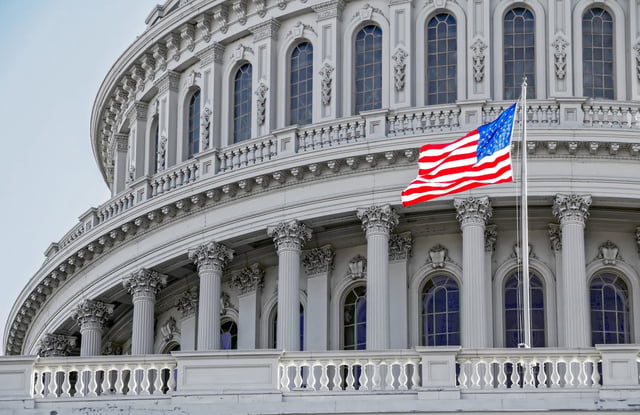 Stock image/file photo: Capitol building in Washington DC with an American flag.