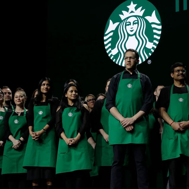FILE - Starbucks baristas stand on stage, March 20, 2019, during an annual shareholders meeting in Seattle. (AP Photo/Ted S. Warren, file)
