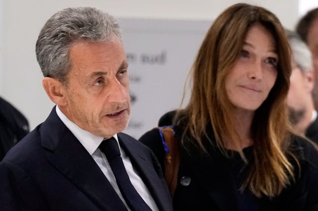 Former French President Nicolas Sarkozy, next to his wife Carla Bruni Sarkozy, speaks after a Paris court sentenced him to 5 years in prison and said he'll be incarcerated even if he appeals, after finding him guilty in his trial for alleged illegal campaign financing by Libya, Thursday, Sept. 25, 2025 in Paris. (AP Photo/Michel Euler)