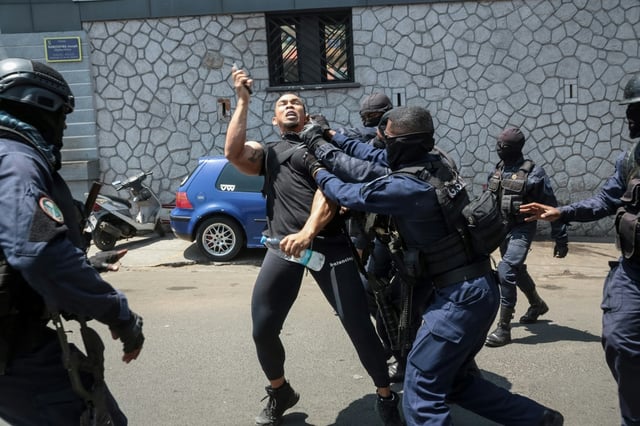 Un manifestant protestant contre les coupures d'eau et d'électricité à Madagascar est interpellé par la police à Antananarivo le 25 septembre 2025