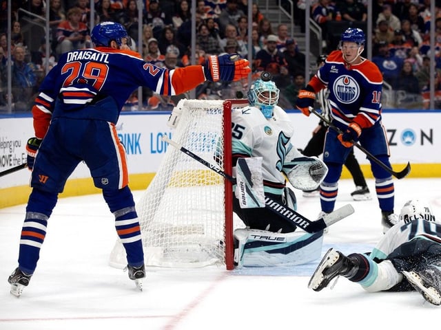 Edmonton Oilers forward Leon Draisaitl tries to knock down his shot that went off the helmet of Seattle Kraken's goaltender Joey Daccord during first period preseason NHL action at Rogers Place, in Edmonton on Wednesday Sept. 24, 2025.