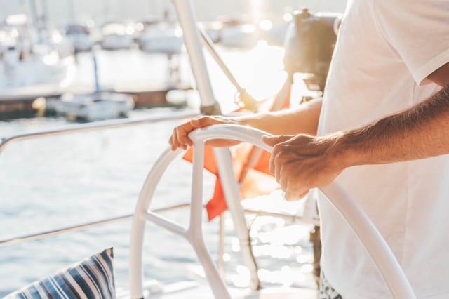 Man driving a yacht.