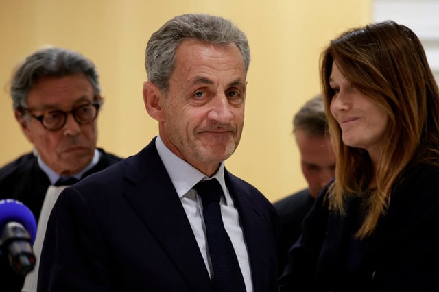 Former French President Nicolas Sarkozy reacts as he leaves with his wife Carla Bruni-Sarkozy after the verdict in his trial with other defendants on charges of corruption and illegal financing of an election campaign related to alleged Libyan funding of his successful 2007 presidential bid, at the courthouse in Paris, France, September 25, 2025. REUTERS/Stephanie Lecocq