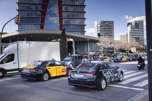 Un taxi y un Uber cerca del recinto de Fira de Barcelona en la Gran Via de l'Hospitalet.