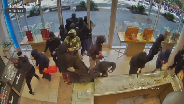 A group of robbers smash through cases in a San Ramon jewelry shop Monday.