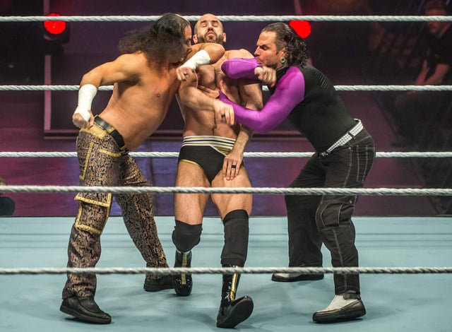 Hardy Boyz and Cesaro (C) battle in the ring during the WWE show at Zenith Arena on May 10, 2017 in Lille, northern France.