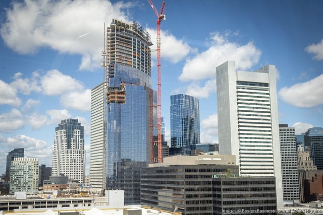 South Station Tower, shown under construction from Fort Point, has signed its first office tenant. The building will open next year.