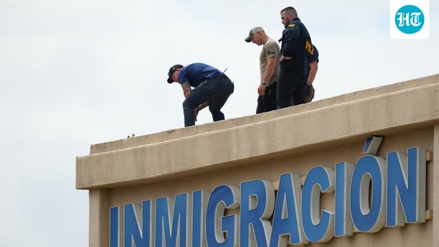 Law enforcement agents look around the roof of a building near the scene of a shooting at a U.S. Immigration and Customs Enforcement office in Dallas on Wednesday, Sept. 24, 2025.
