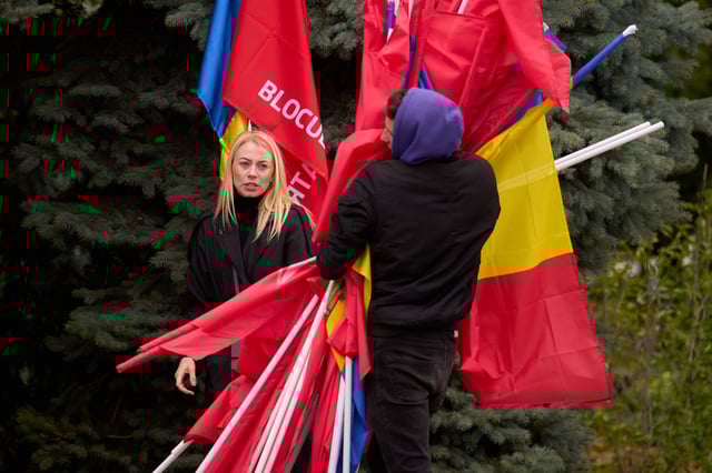 Activists gather flags at the end of a rally of the Russia-friendly Patriotic Electoral Bloc in Chisinau, Moldova, Thursday, Sept. 25, 2025, ahead of parliamentary elections taking place on Sept. 28. (AP Photo/Vadim Ghirda)