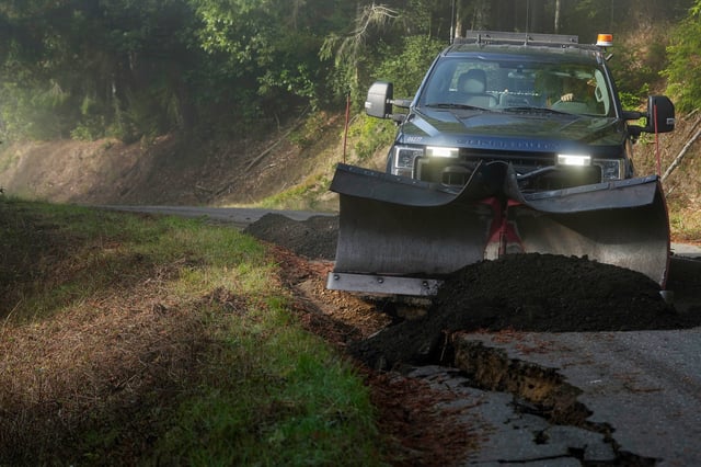 Humboldt County road maintenance supervisor Wayne Tomasini fills in cracks with dirt on a road in Humboldt County, Calif., Friday, Dec. 6, 2024. The cracks were caused by a 7.0 earthquake the day before.