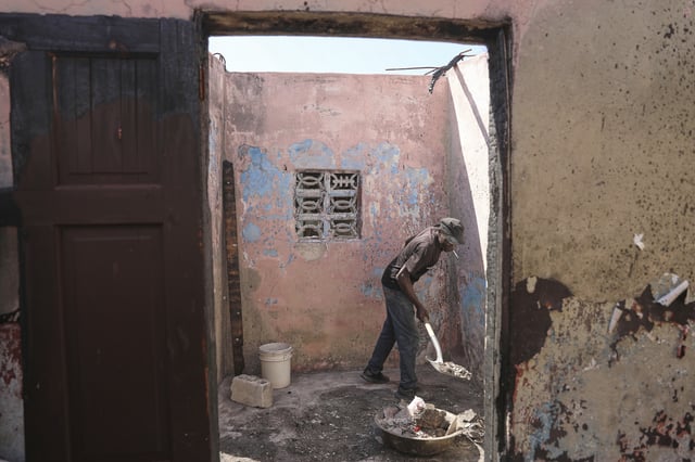 Francick Ferolis cleans his house after it was damaged by gang violence in the Solino neighborhood of Port-au-Prince, Haiti, Wednesday, Sept. 10, 2025. (AP Photo/Odelyn Joseph)