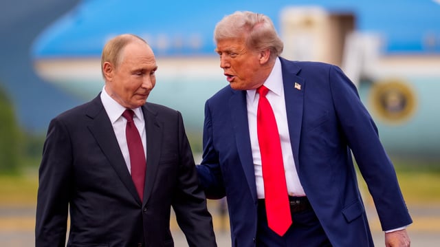ANCHORAGE, ALASKA - AUGUST 15: (EDITOR'S NOTE: Alternate Crop) U.S. President Donald Trump (R) greets Russian President Vladimir Putin as he arrives at Joint Base Elmendorf-Richardson on August 15, 2025 in Anchorage, Alaska. The two leaders are meeting for peace talks aimed at ending the war in Ukraine.